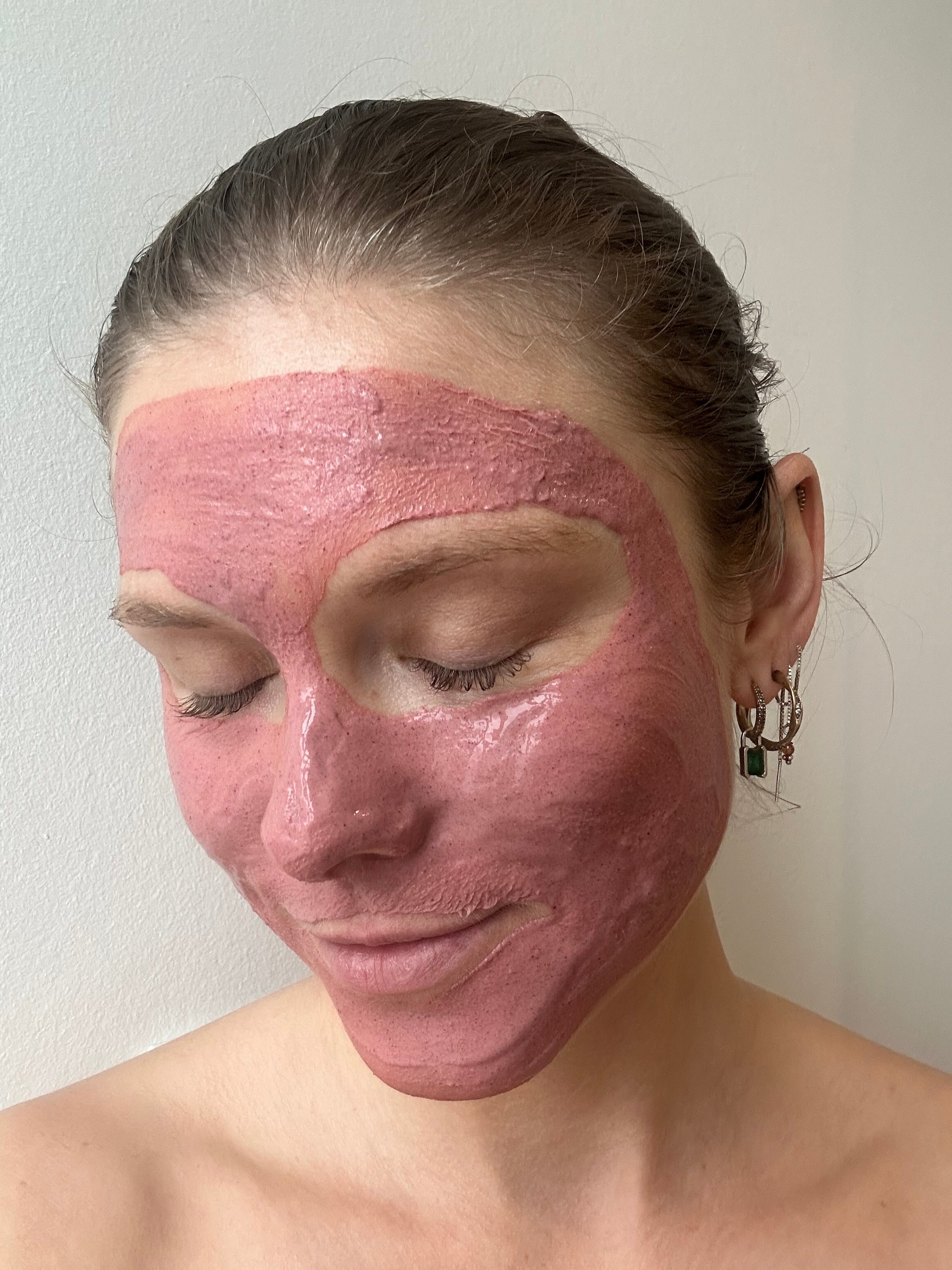Woman wearing AKINA Clay Ceremony pink clay face mask on skin, showing smooth application and texture